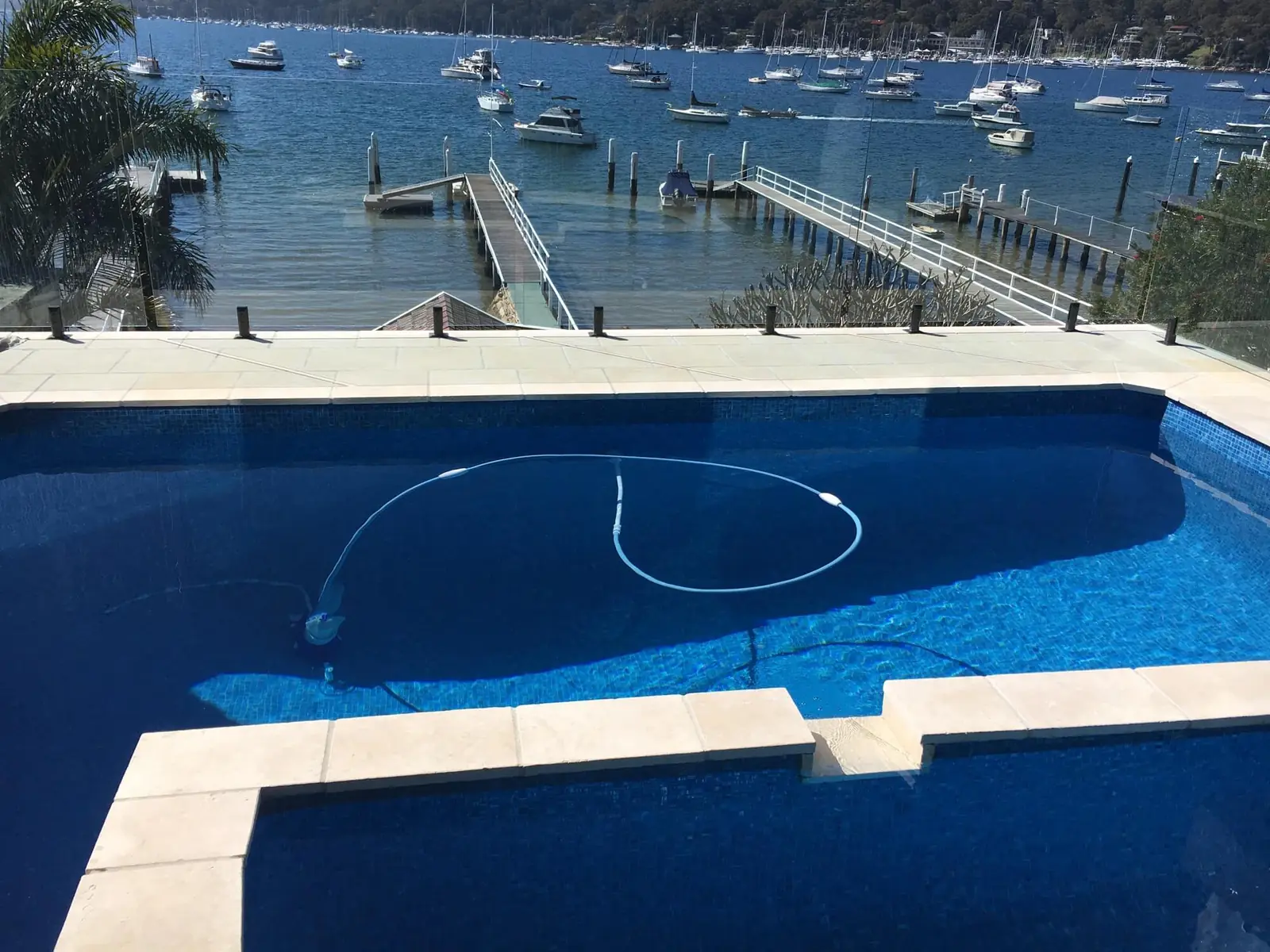 Harbourside pool with glass fencing overlooking moored boats